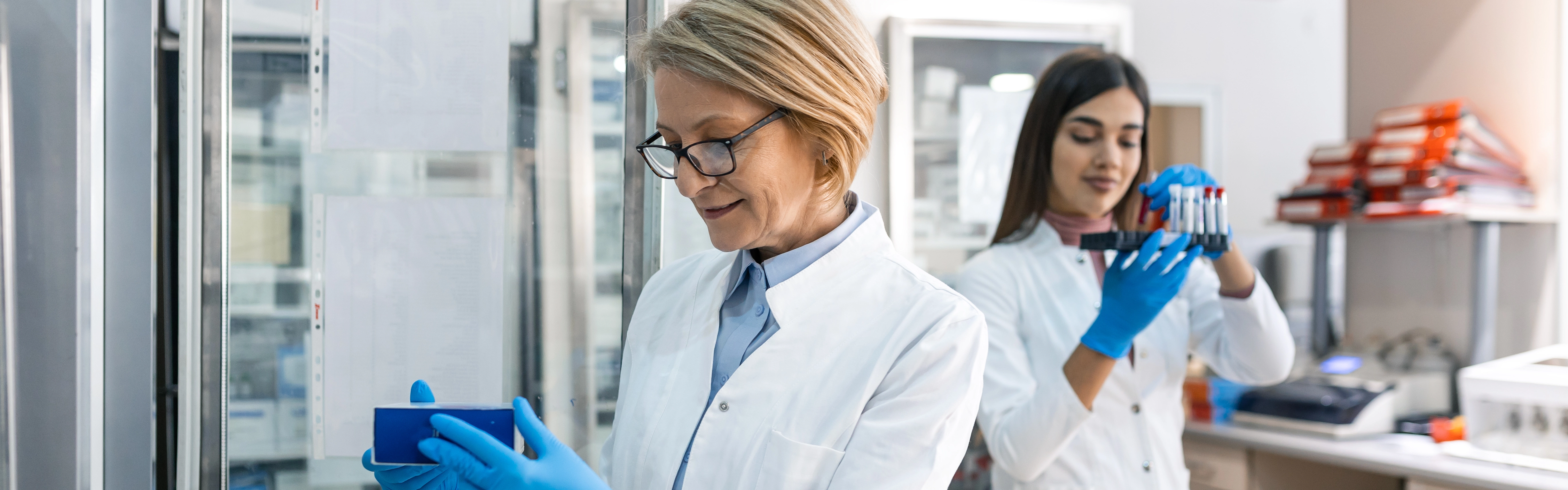 Two women in a scientific laboratory hording equipment 